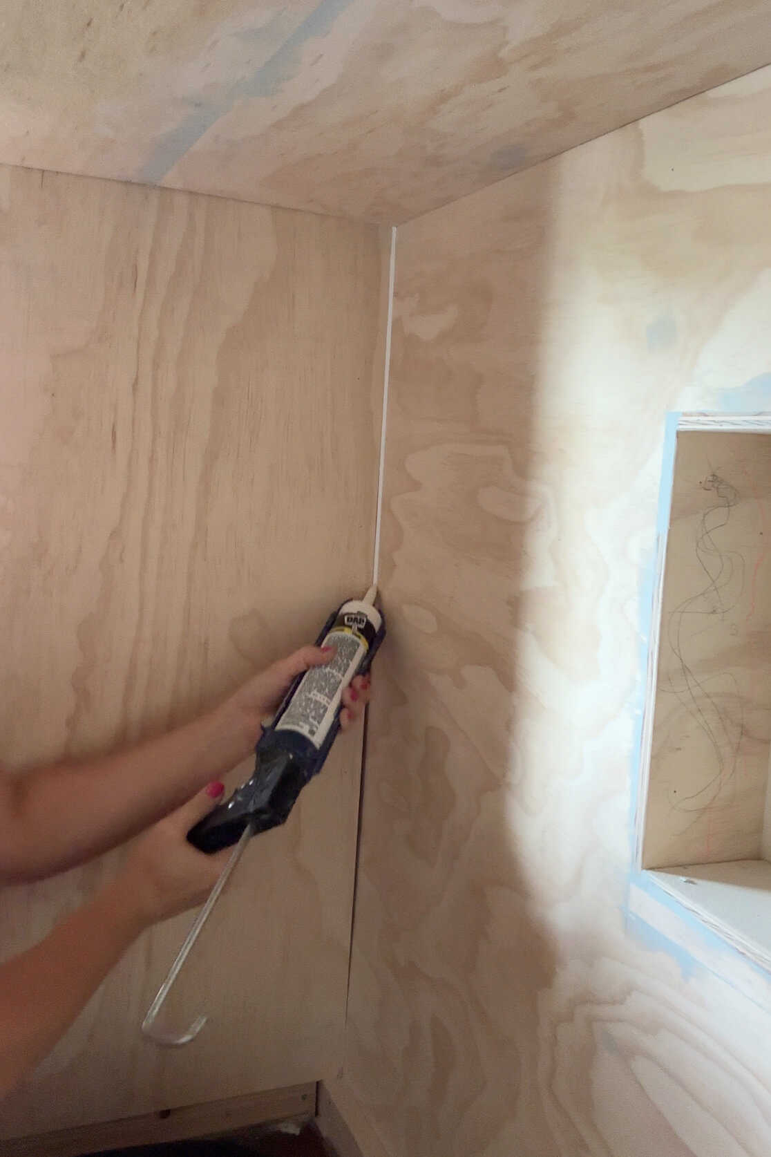 Caulking seams in a DIY bunk bed.